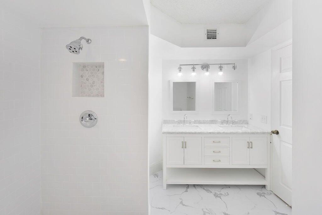 17340 Boca Club Boulevard, Unit 704 Boca Raton, FL 33487 - Photo 16 of 27 a bathroom with a sink mirror and vanity