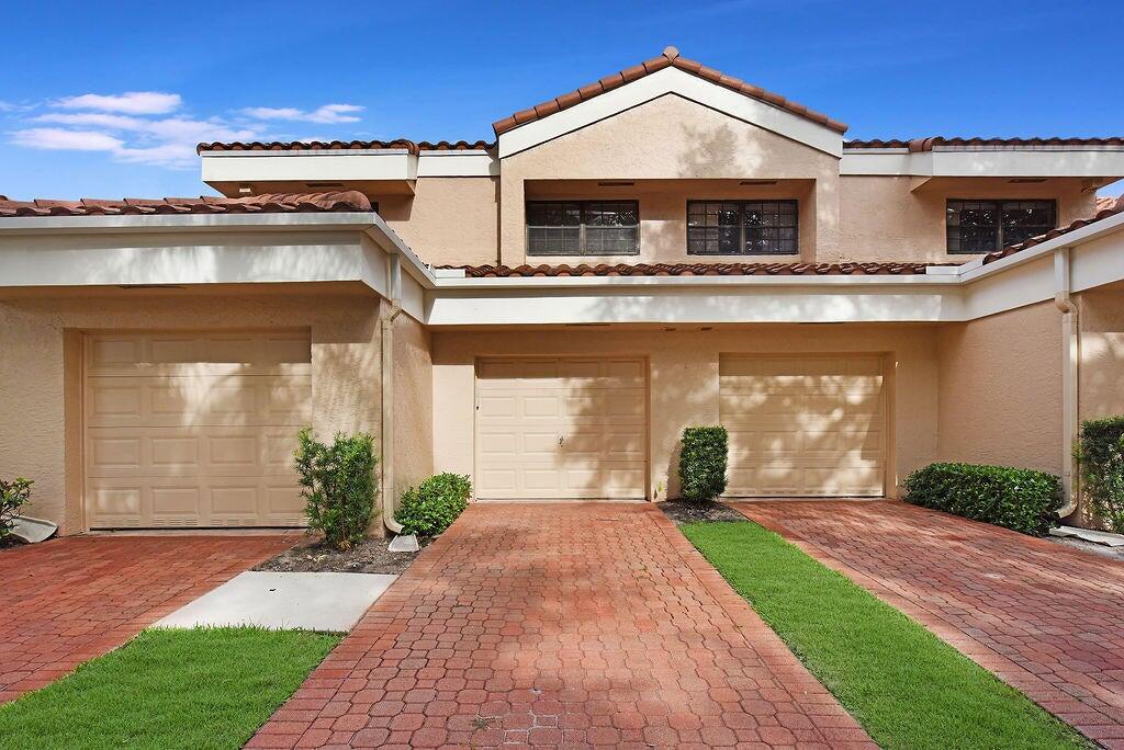 17340 Boca Club Boulevard, Unit 704 Boca Raton, FL 33487 - Photo 2 of 27 front view of a house with a yard