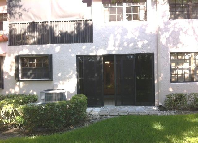17340 Boca Club Boulevard, Unit 704 Boca Raton, FL 33487 - Photo 3 of 27 a front view of a house with a yard and garage