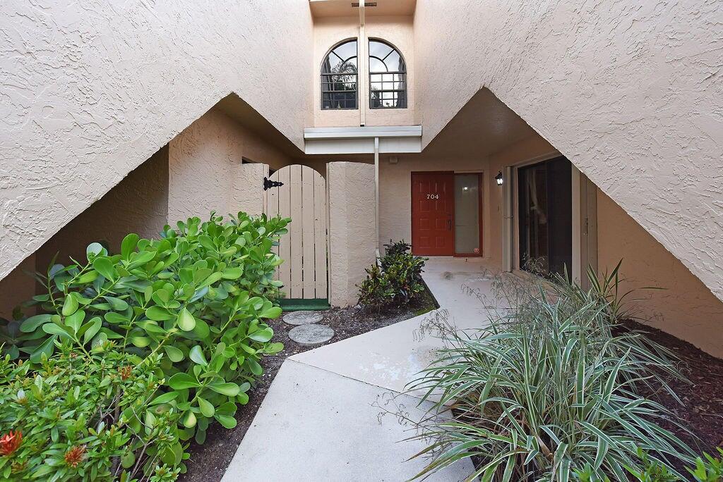 17340 Boca Club Boulevard, Unit 704 Boca Raton, FL 33487 - Photo 4 of 27 a front view of a house with a yard