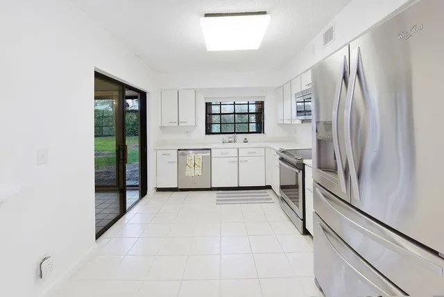 a kitchen with stainless steel appliances a refrigerator sink and cabinets