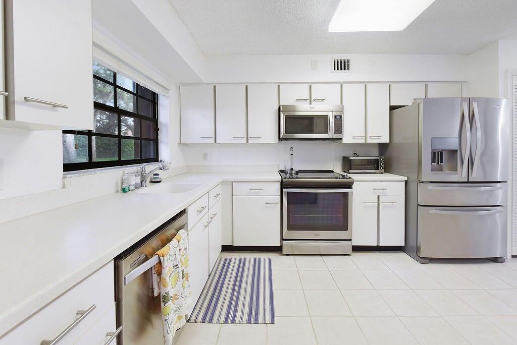 17340 Boca Club Boulevard, Unit 704 Boca Raton, FL 33487 - Photo 10 of 27 a kitchen with a sink stove and refrigerator