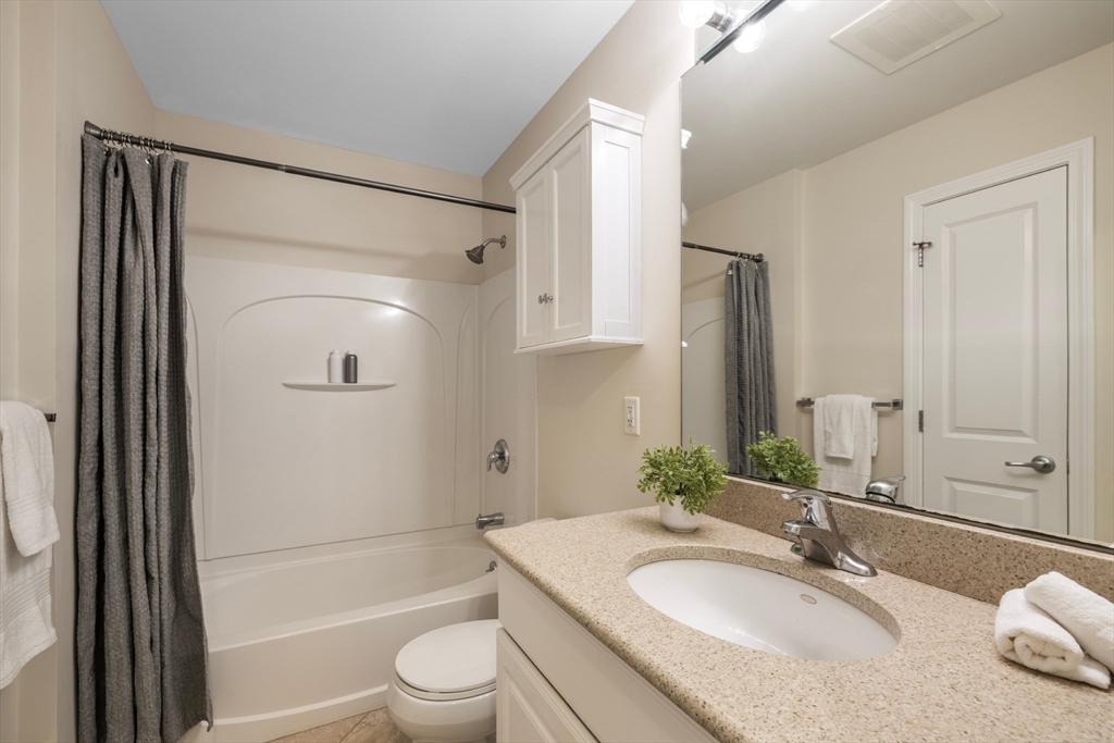 320 Rindge Avenue, Unit 303 Cambridge, MA 02140 - Photo 12 of 28 a bathroom with a granite countertop sink toilet and shower
