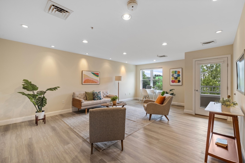 320 Rindge Avenue, Unit 303 Cambridge, MA 02140 - Photo 2 of 28 a living room with furniture and a wooden floor