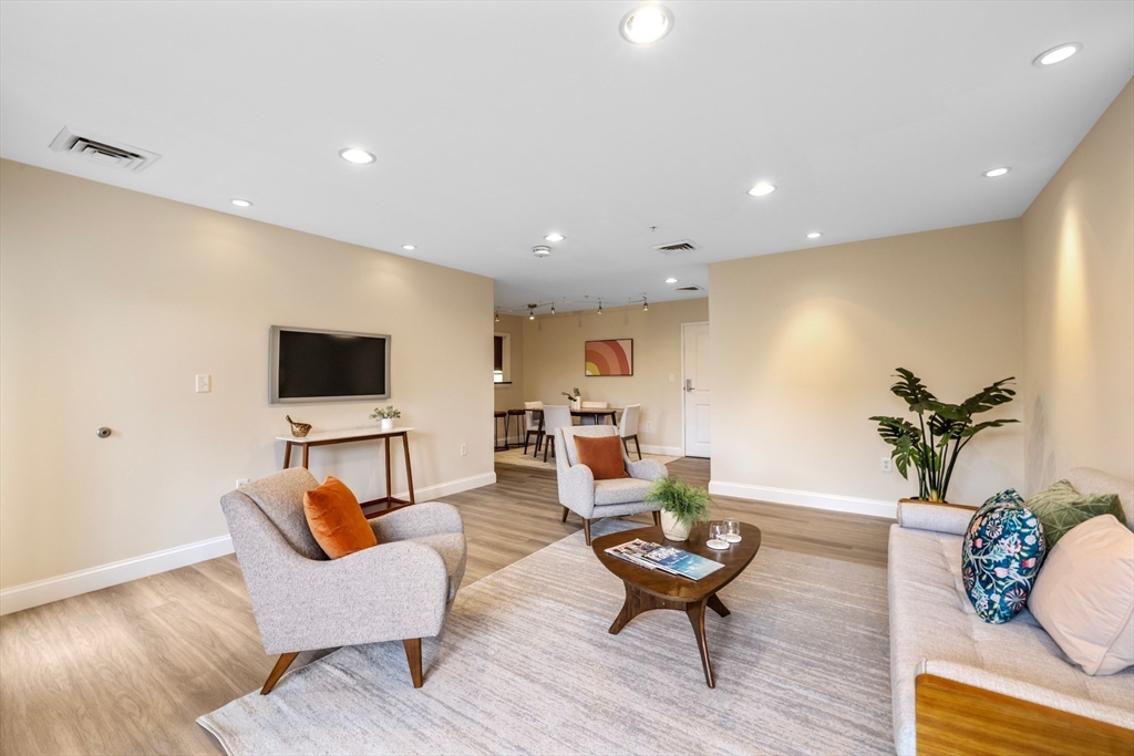 320 Rindge Avenue, Unit 303 Cambridge, MA 02140 - Photo 5 of 28 a living room with furniture and a wooden floor