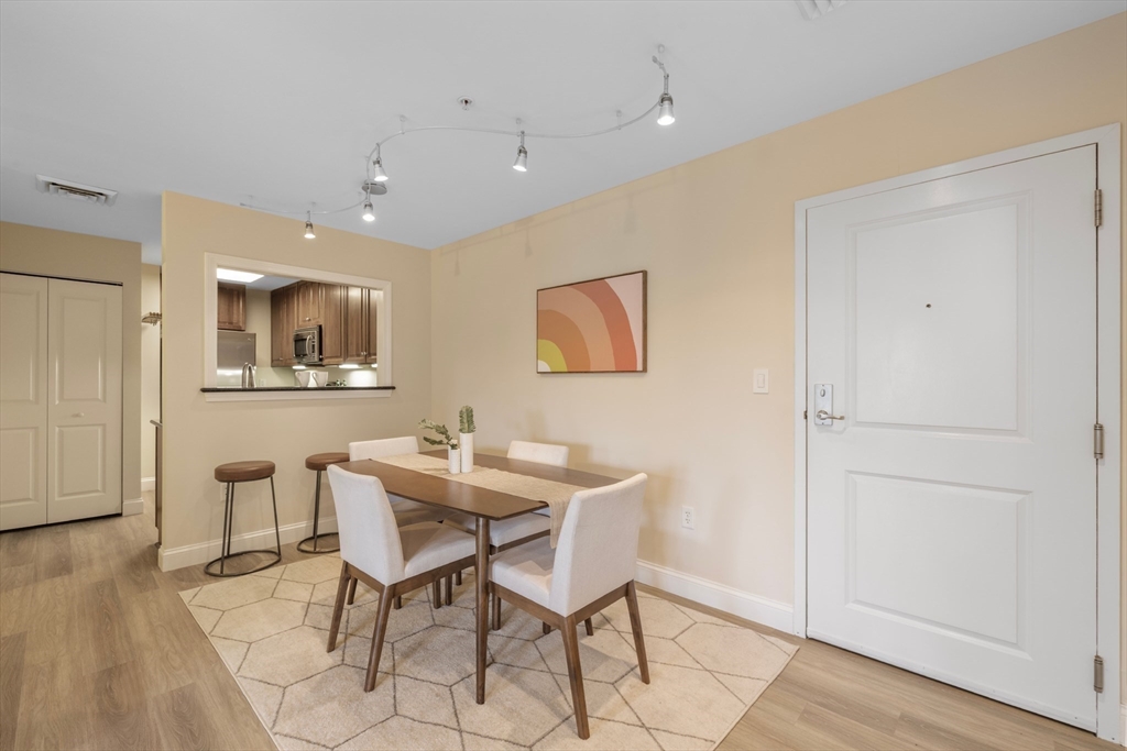 320 Rindge Avenue, Unit 303 Cambridge, MA 02140 - Photo 6 of 28 a view of a dining room with furniture and wooden floor