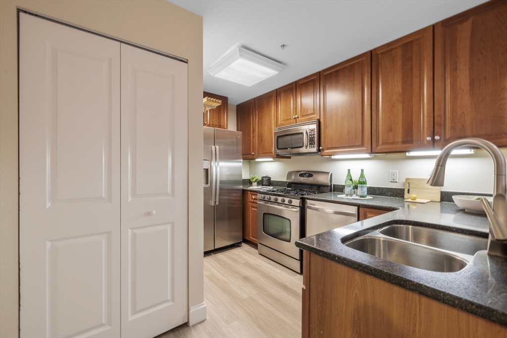 320 Rindge Avenue, Unit 303 Cambridge, MA 02140 - Photo 9 of 28 a kitchen with stainless steel appliances granite countertop a refrigerator sink and cabinets