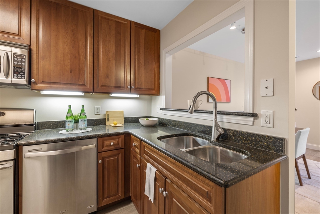 320 Rindge Avenue, Unit 303 Cambridge, MA 02140 - Photo 10 of 28 a kitchen with stainless steel appliances granite countertop a sink stove and cabinets