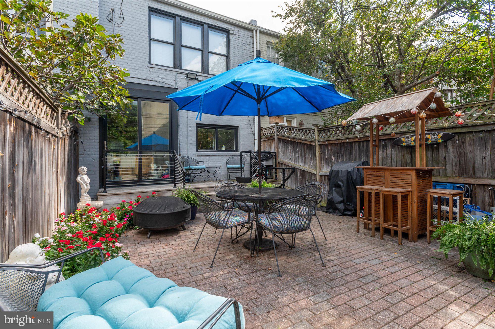 1906 37th Street Northwest Washington, DC 20007 - Photo 5 of 22 a patio with a table and chairs under an umbrella
