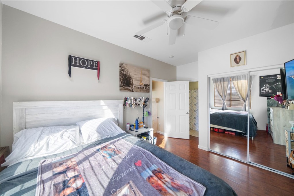 29611 Camino Cristal Menifee, CA 92584 - Photo 12 of 33 a bedroom with a large bed and a chandelier