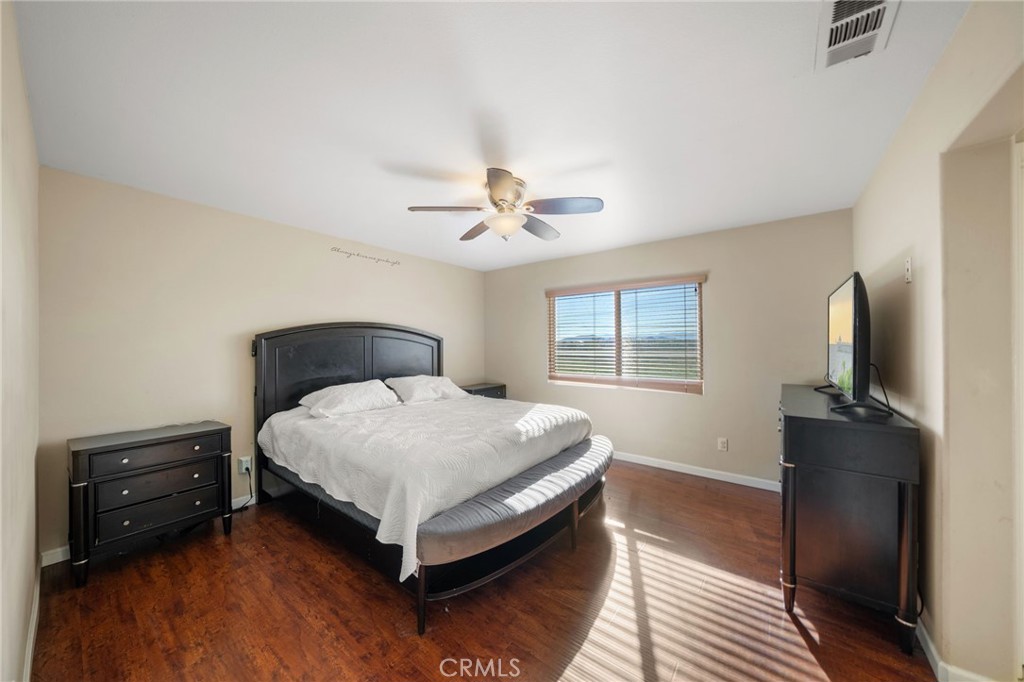 29611 Camino Cristal Menifee, CA 92584 - Photo 23 of 33 a bedroom with a bed and a flat tv screen on a dresser