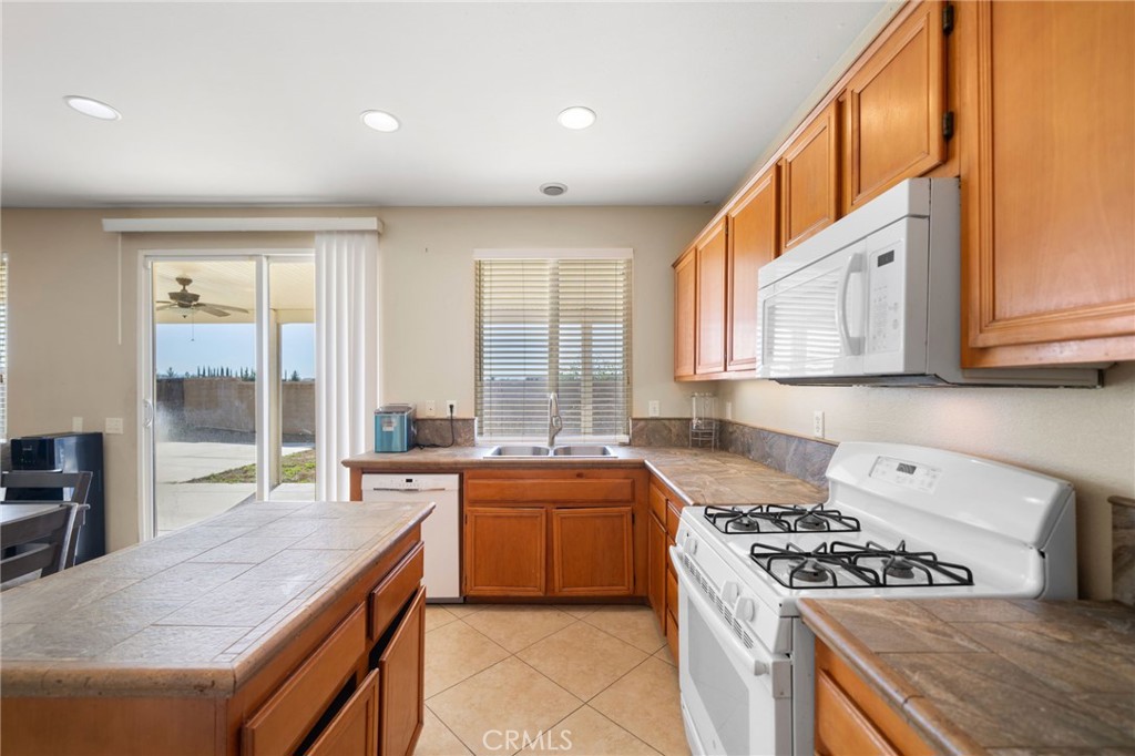 29611 Camino Cristal Menifee, CA 92584 - Photo 7 of 33 a kitchen with a stove a sink and a refrigerator