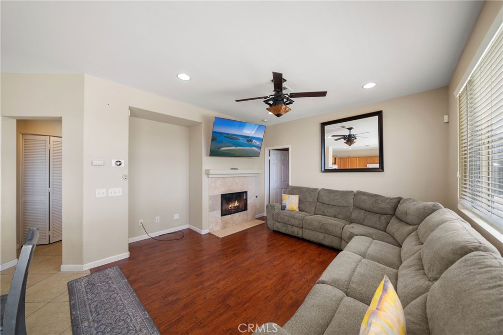29611 Camino Cristal Menifee, CA 92584 - Photo 9 of 33 a living room with furniture a fireplace and a flat screen tv