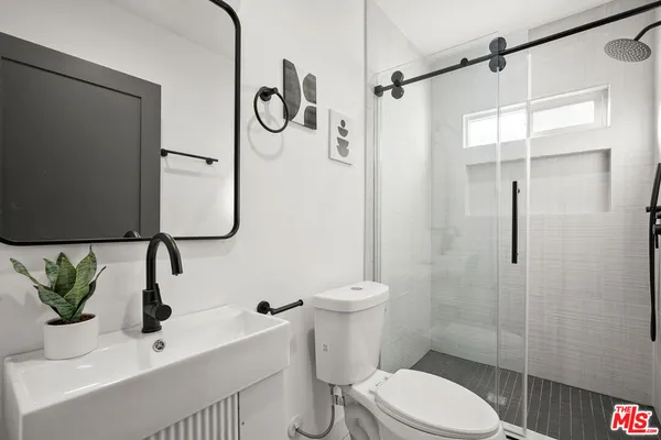 a bathroom with a sink a toilet and shower