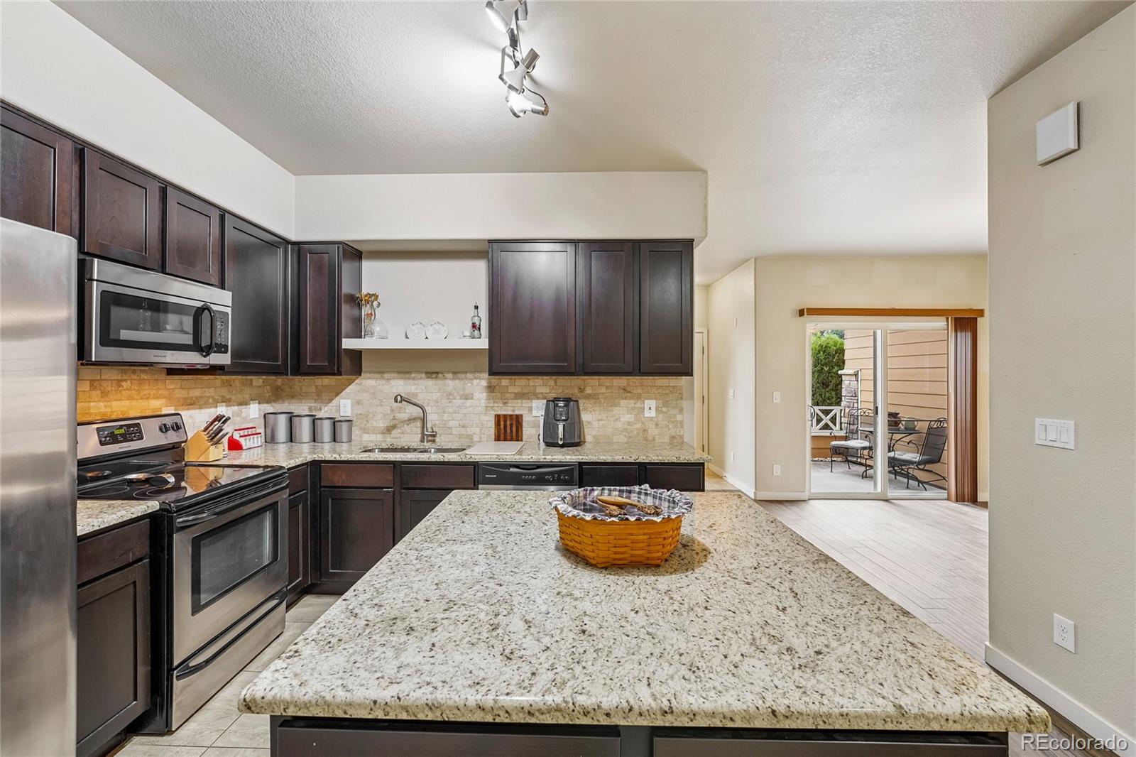 3611 South Perth Circle, Unit 102 Aurora, CO 80013 - Photo 12 of 40 a kitchen with sink a stove and cabinets