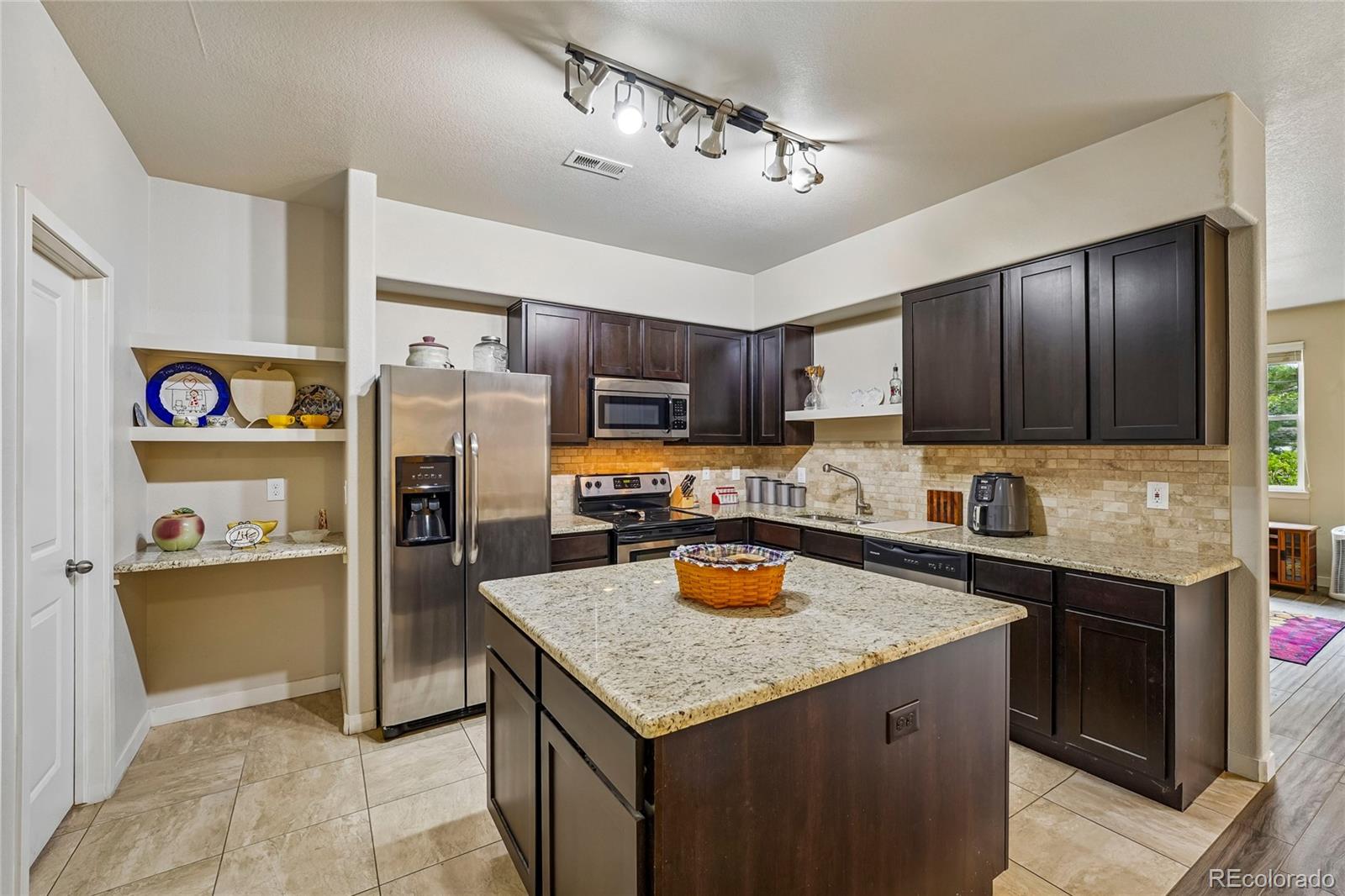 3611 South Perth Circle, Unit 102 Aurora, CO 80013 - Photo 13 of 40 a kitchen with refrigerator and cabinets