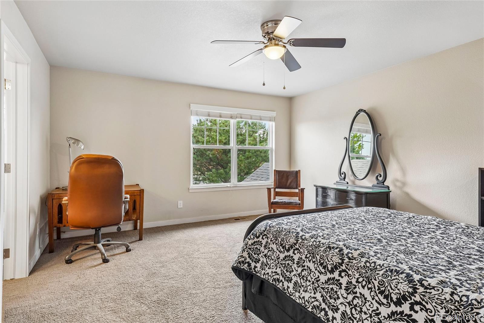 3611 South Perth Circle, Unit 102 Aurora, CO 80013 - Photo 25 of 40 a bedroom with a bed a desk and chair