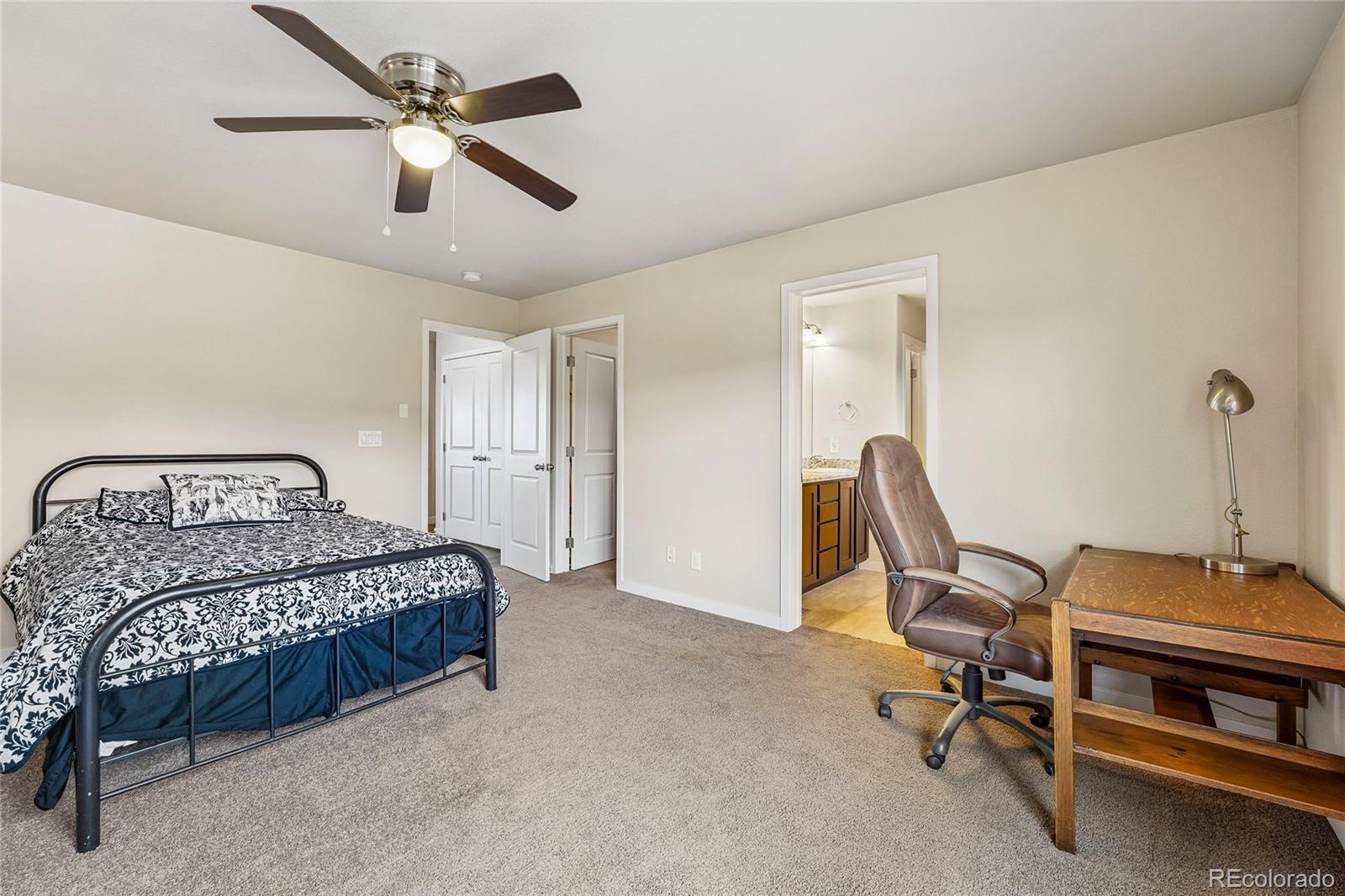3611 South Perth Circle, Unit 102 Aurora, CO 80013 - Photo 27 of 40 a bedroom with a bed and a ceiling fan