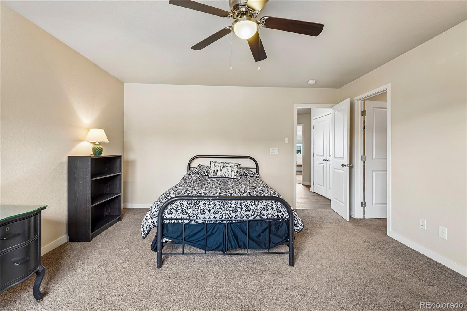 3611 South Perth Circle, Unit 102 Aurora, CO 80013 - Photo 28 of 40 a bedroom with a bed and a chandelier