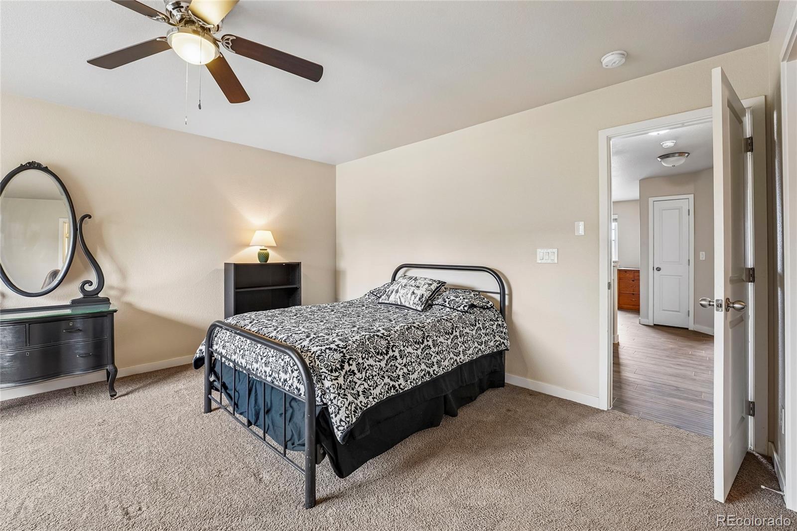 3611 South Perth Circle, Unit 102 Aurora, CO 80013 - Photo 29 of 40 a bedroom with a bed and a chandelier