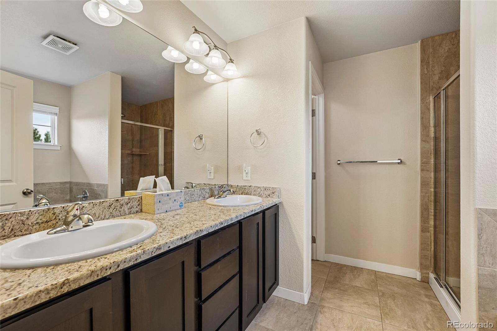 3611 South Perth Circle, Unit 102 Aurora, CO 80013 - Photo 30 of 40 a bathroom with a granite countertop sink and a mirror