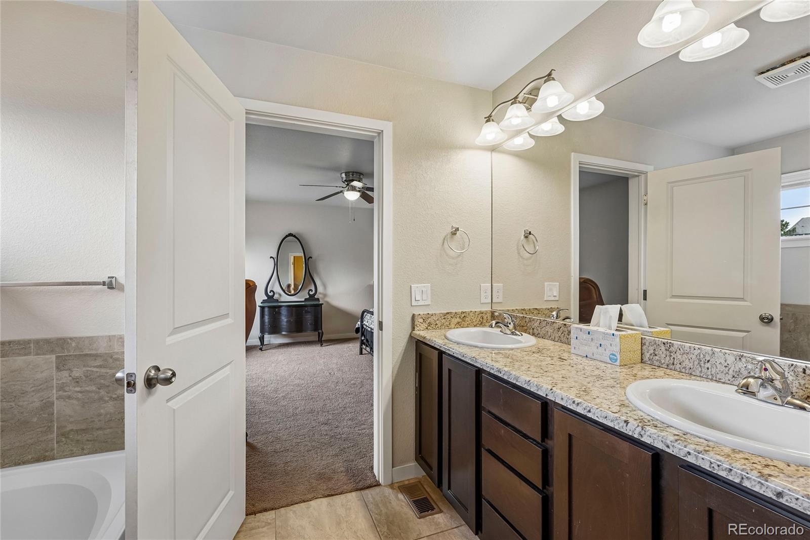 3611 South Perth Circle, Unit 102 Aurora, CO 80013 - Photo 31 of 40 a en suite bathroom with a sink double vanity and a mirror