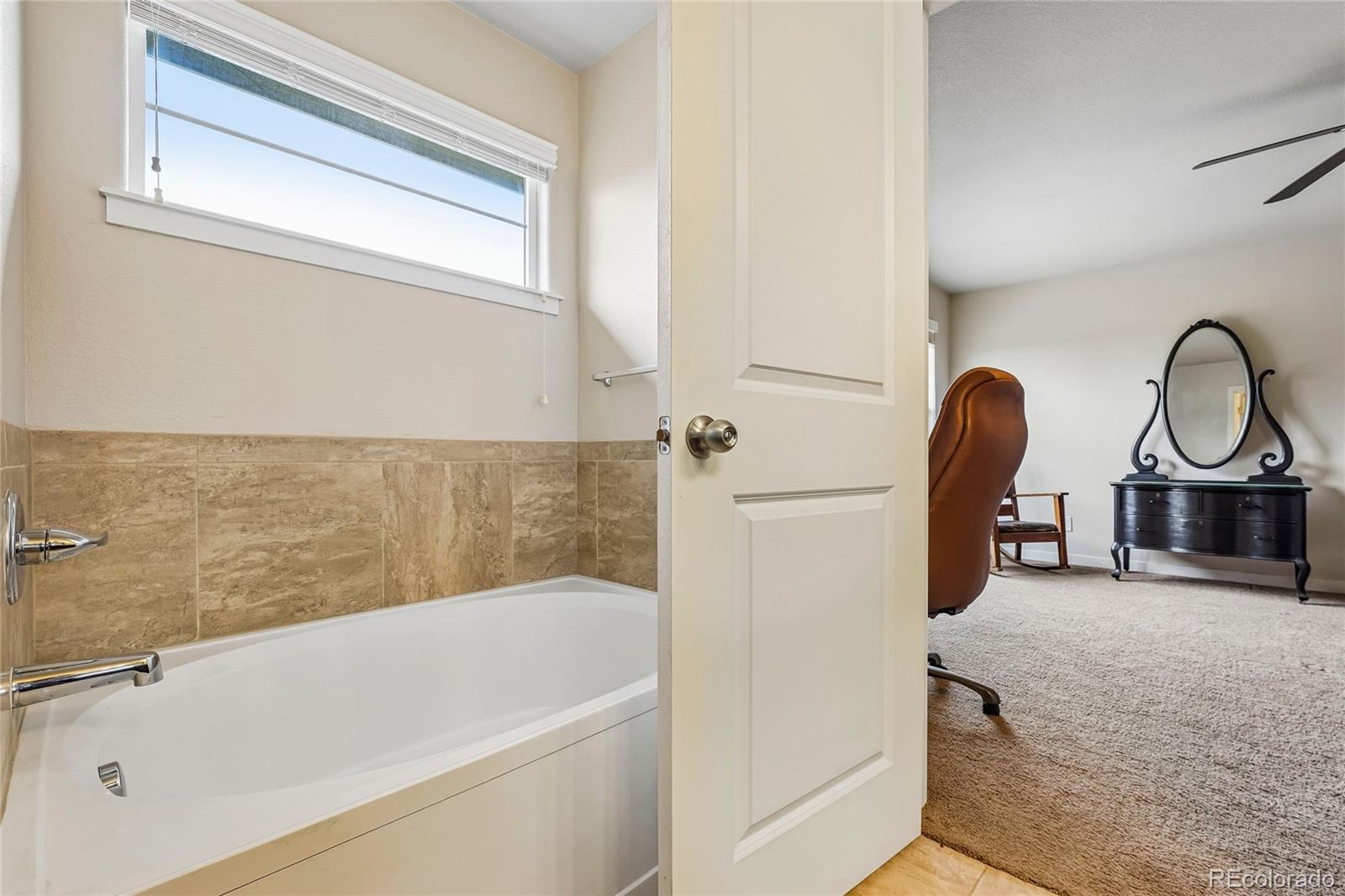 3611 South Perth Circle, Unit 102 Aurora, CO 80013 - Photo 32 of 40 a bathroom with a tub sink and mirror
