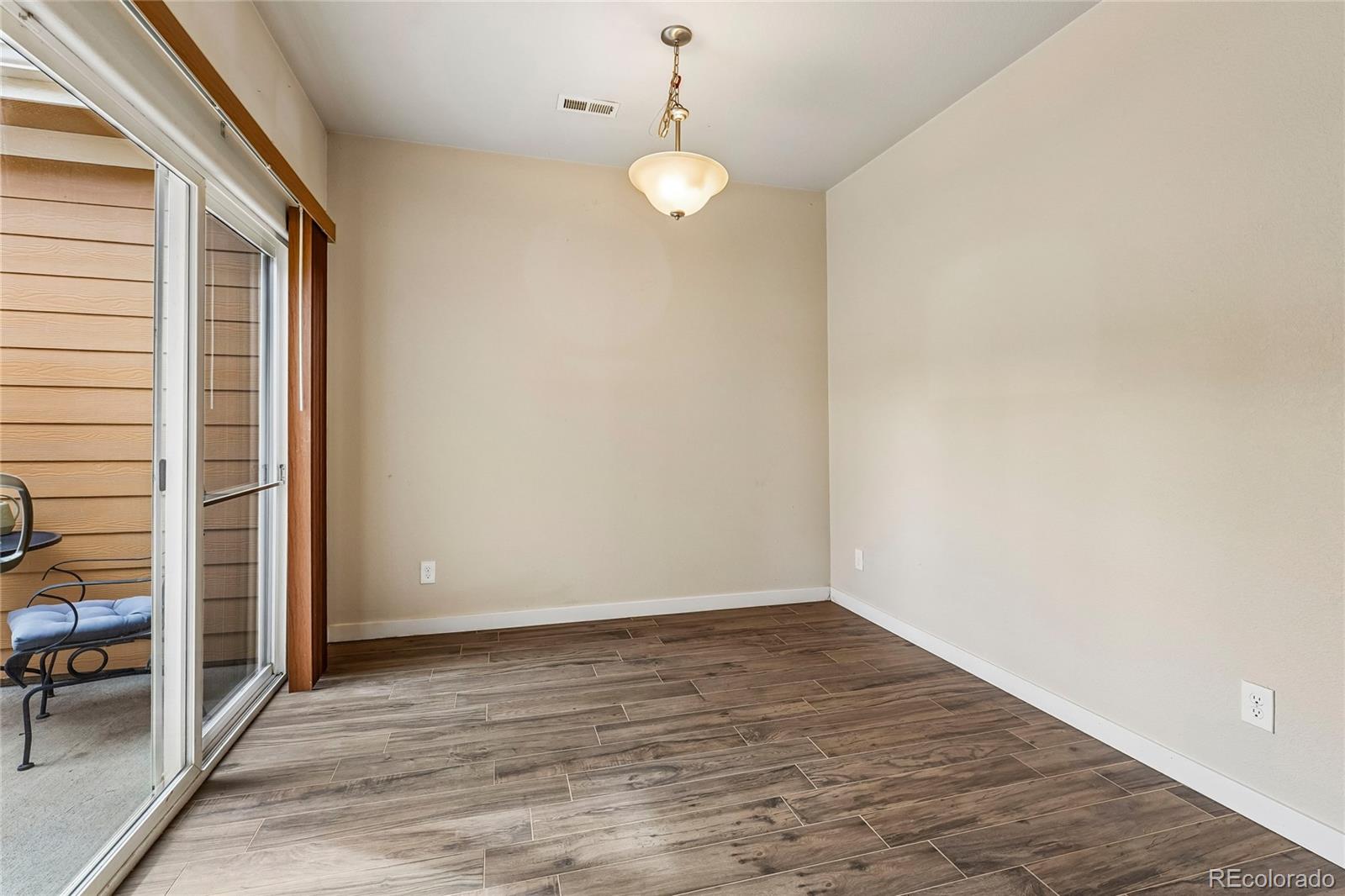 3611 South Perth Circle, Unit 102 Aurora, CO 80013 - Photo 8 of 40 a view of an empty room with wooden floor and a window