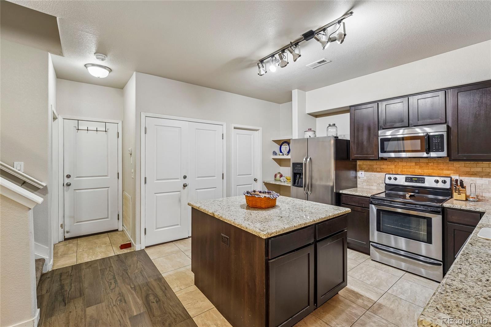3611 South Perth Circle, Unit 102 Aurora, CO 80013 - Photo 9 of 40 a kitchen with refrigerator cabinets and wooden floor