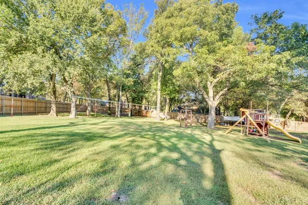 a view of a house with a big yard and large trees
