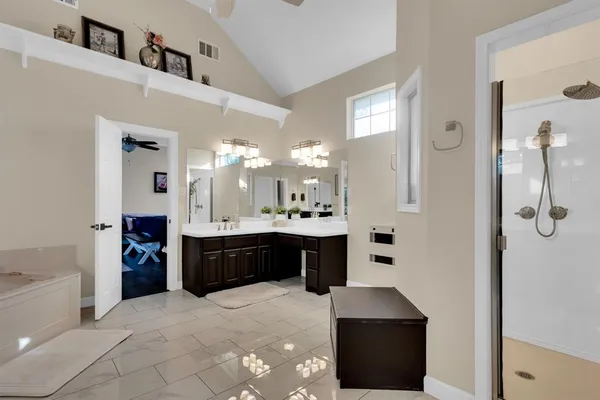 a large bathroom with a double vanity sink a large mirror and shower
