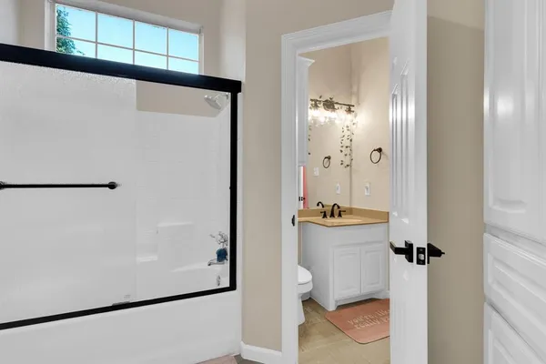 a bathroom with a sink and mirror with toilet