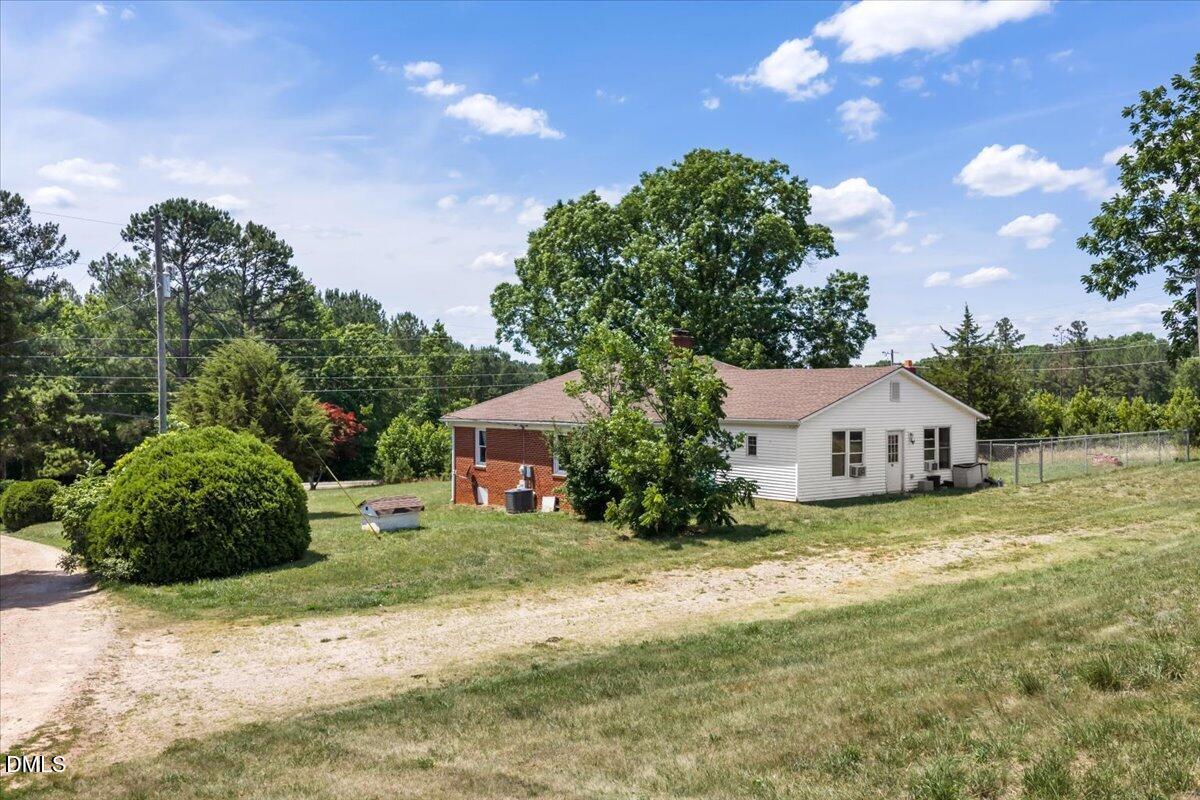 109 Little Ponderosa Road Macon, NC 27551 - Photo 22 of 32 a front view of a house with a garden and yard