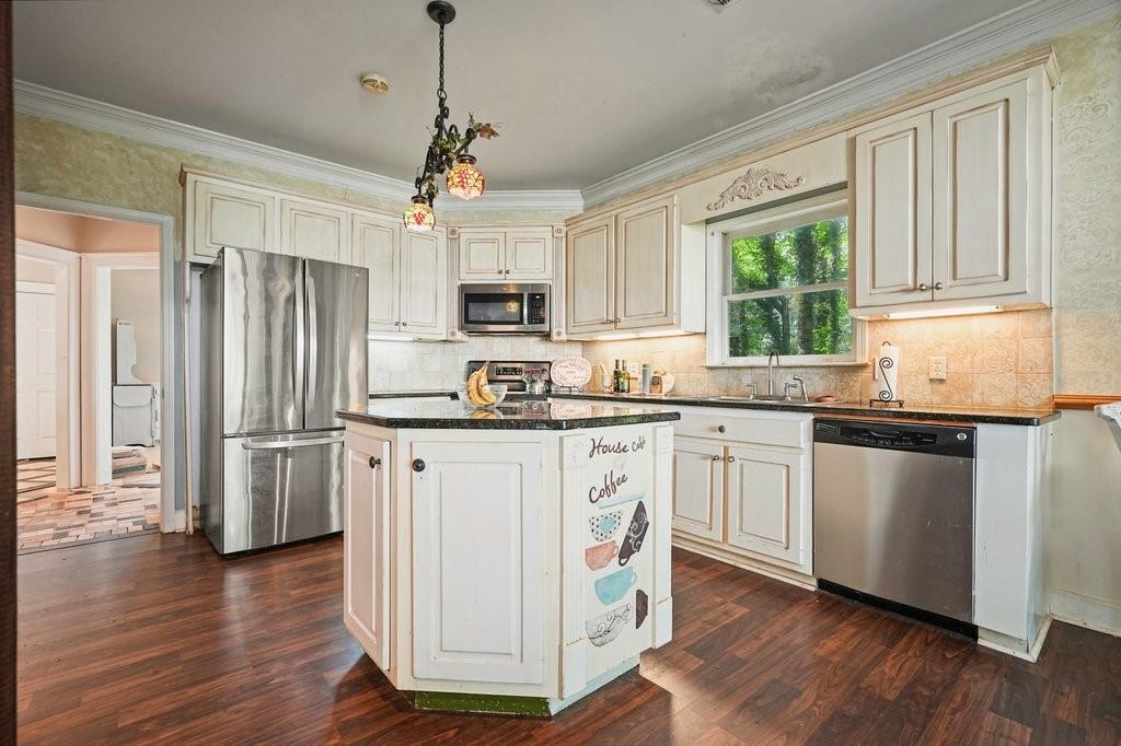 1513 Old Jones Road Alpharetta, GA 30004 - Photo 7 of 62 a kitchen with kitchen island granite countertop a sink appliances cabinets and a counter top space