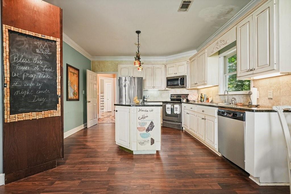 1513 Old Jones Road Alpharetta, GA 30004 - Photo 8 of 62 a kitchen with stainless steel appliances granite countertop a refrigerator a sink dishwasher a stove and white cabinets with wooden floor