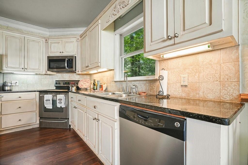 1513 Old Jones Road Alpharetta, GA 30004 - Photo 10 of 62 a kitchen with stainless steel appliances granite countertop a sink and dishwasher a stove top oven with wooden floor