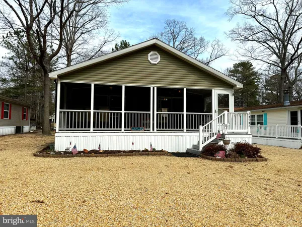 a front view of a house with a large tree
