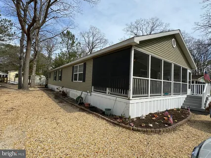 a view of a house with a yard and large tree