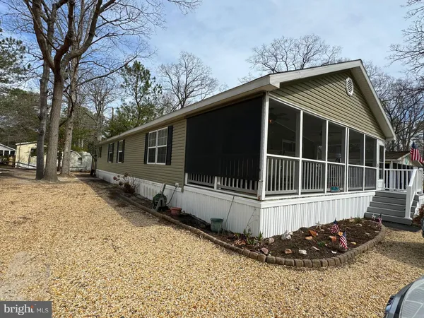 a view of a house with a yard and large tree
