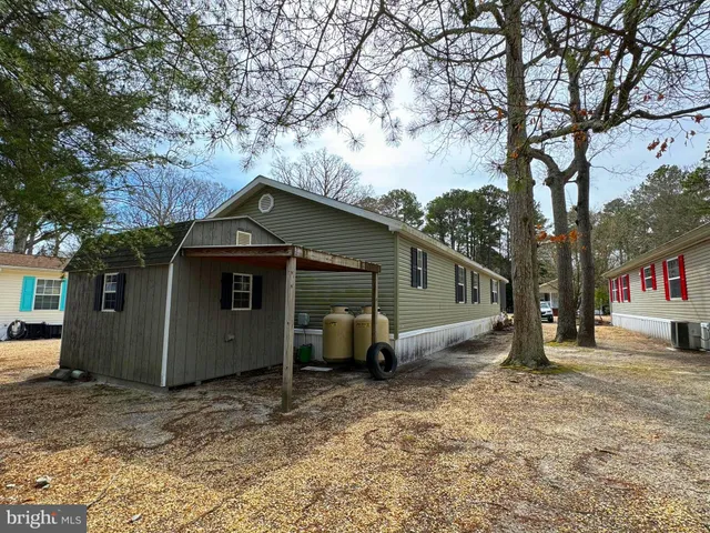 a view of a house with a yard and large tree