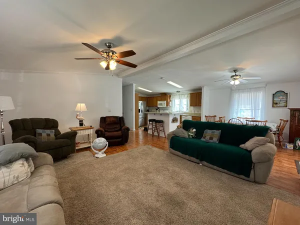 a living room with furniture a ceiling fan and a rug