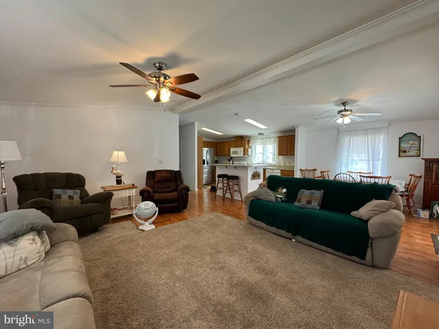 a living room with furniture a ceiling fan and a rug