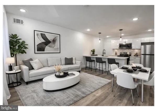 a living room with furniture and kitchen view