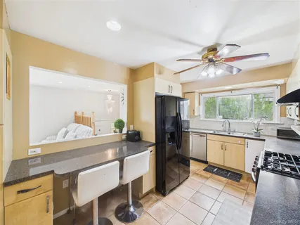 a kitchen with granite countertop a sink appliances cabinets and furniture