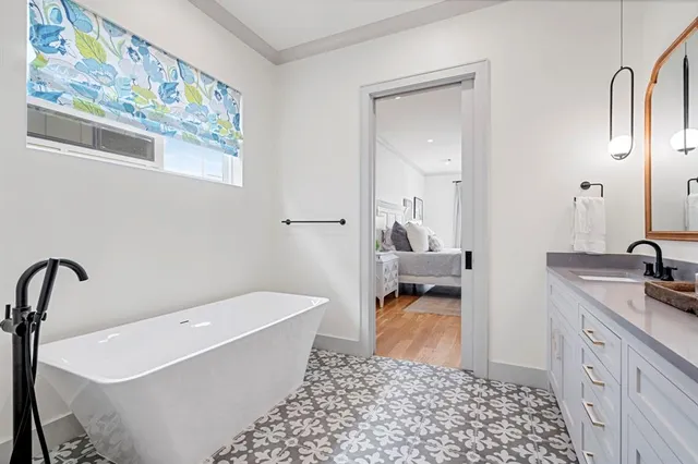 a bathroom with a tub sink and mirror