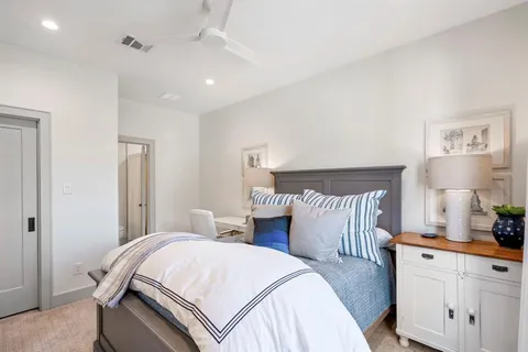 a bedroom with a bed and a lamp on dresser