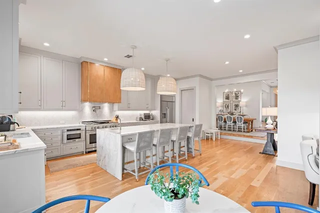 a kitchen with stainless steel appliances kitchen island granite countertop a stove and white cabinets