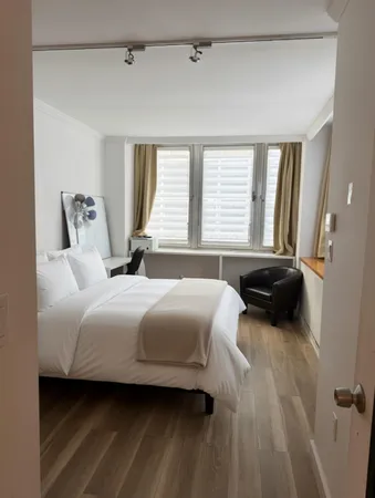 a bedroom with a bed a couch and a window