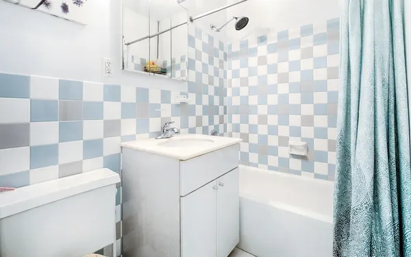 a bathroom with a sink a toilet and a shower curtain
