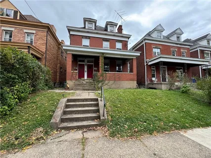 a front view of a residential apartment building with a yard